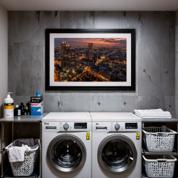 An Art Wall Room Mockup generated with AI for Print On Demand Seller. The mockup features a Cyberpunk Style Laundry Room with a framed photography print of the Shinjuku Business District at Sunset on the wall
