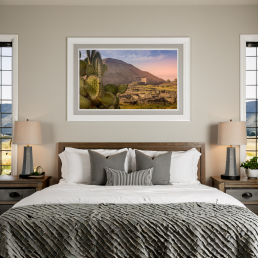 An Art Wall Room Mockup generated with AI for Print On Demand Seller. The mockup features a Modern Farmhouse Style Bedroom with a framed photography print of a the Teotihuacan Pyramids and Cactus at sunrise on the wall